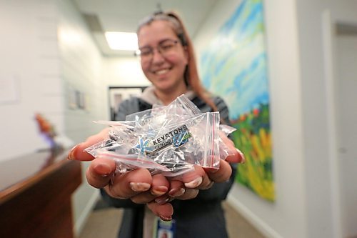 A smiling Cassie Martens, the ticketing and marketing coordinator for the Keystone Centre in Brandon, holds out a large handful of pins on Wednesday that celebrate the 50th anniversary of the facility. The Keystone Centre will hold its official 50th anniversary celebration this coming Saturday. (Matt Goerzen/The Brandon Sun)