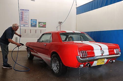 Westman's Layne Green washes his 1966 Mustang GT Custom while his daughter Jalayna watches from the back seat. (Michele McDougall/The Brandon Sun) 