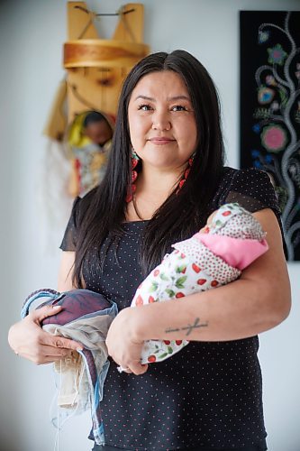 Midwife Melissa Brown Sveinson with a handmade plush placenta and a doll swaddled in a traditional moss bag. (Photos by Mike Deal/Winnipeg Free Press)