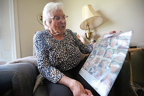 Josephine "Jo" Stokotelny, seen here her apartment at Loray Manor in Dauphin, holds up a copy of the Winnipeg Free Press from 2023 showing the photos of most of the individuals who died as a result of the June 15, 2023 collision near Carberry that claimed the lives of 17 people from the city of Dauphin. Stokotelny says she prays for them every day. (Matt Goerzen/The Brandon Sun)