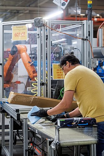 MIKE DEAL / FREE PRESS
Ernesto Tan, a finisher at Duha Group, works beside a robotic arm that inserts a rivet post for a fan swatch. The fourth-generation family business makes colour swatches and other colour marketing tools located at 750 Bradford Street.
See Aaron App story
240613 - Thursday, June 13, 2024.