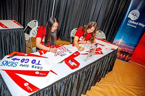 NIC ADAM / FREE PRESS
Tamara Nelson (left) and Catrina Peters, volunteers at the United Way 50/50 sign making booth, make signs to cheer on runners at the upcoming Winnipeg Marathon.
240614 - Friday, June 14, 2024.

Reporter: ?