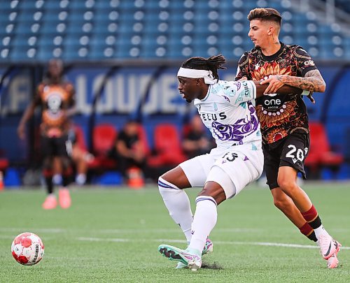 Daniel Crump / Winnipeg Free Press. Pacific&#x573; Kunle Dada-Luke (13) holds off Valour&#x573; Diogo Dias da Ressureio (20) as they jockey for the ball. Valour FC take on Pacific FC in the last of a three game homestead at Winnipeg Stadium Friday night. June 14, 2024.