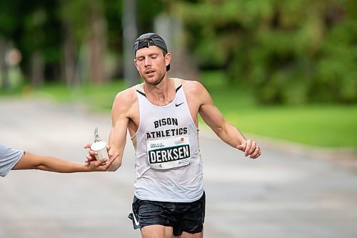 BROOK JONES / FREE PRESS
Tyler Derksen (right) grabs a cup of water from Manitoba Marathon volunteer Vern Dalusong as he runs down Wellington Crescent while competing in the men's full marathon, which was the 46th running of the Manitoba Marathon in Winnipeg, Man., Sunday, June 16, 2024.