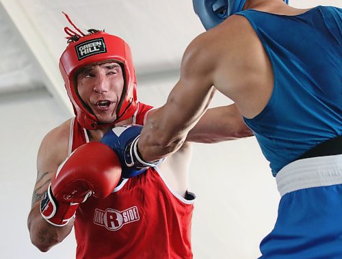 Kyle Grenier of Winnipeg, in red, absorbs a punch from Marco Mazzini of Regina during the Peak Boxing Event in a tent at the Riverbank Discovery Centre on Saturday evening. The five-hour show featured 25 bouts. Grenier won the bout. (Perry Bergson/The Brandon Sun)