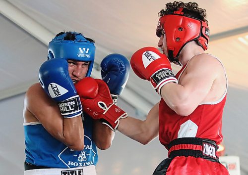 Ethan Ruttle, in red, sneaks through an upper cut to the chin of Dillon (The Villian) Masuskapoe during the Peak Boxing Event in a tent at the Riverbank Discovery Centre on Saturday evening. Ruttle earned the victory. The five-hour show featured 25 bouts. (Perry Bergson/The Brandon Sun)