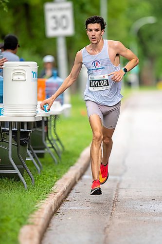 BROOK JONES / FREE PRESS
Andrew Taylor grabs a Nuun Endurance sport drink at a hydration station as he runs down Wellington Crescent on his way to winning the men's full marathon, which was the 46th running of the Manitoba Marathon in Winnipeg, Man., Sunday, June 16, 2024.