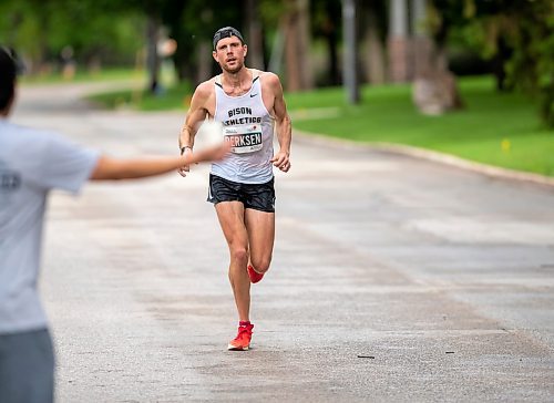 BROOK JONES / FREE PRESS
Tyler Derksen is focused on grabbing a cup of water from Manitoba Marathon volunteer Vern Dalusong as he runs down Wellington Crescent while competing in the men's full marathon, which was the 46th running of the Manitoba Marathon in Winnipeg, Man., Sunday, June 16, 2024.