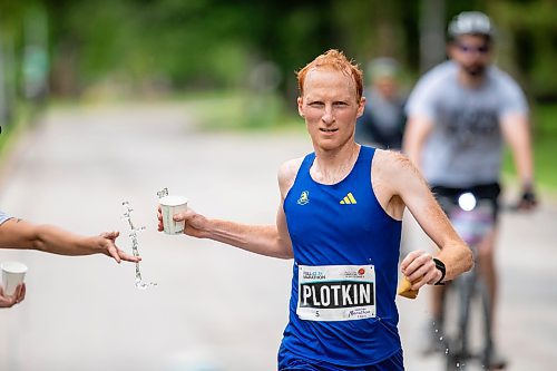 BROOK JONES / FREE PRESS
David Plotkin (right) grabs a cup of water from Manitoba Marathon volunteer Vern Dalusong as he runs down Wellington Crescent while competing in the men's full marathon, which was the 46th running of the Manitoba Marathon in Winnipeg, Man., Sunday, June 16, 2024.