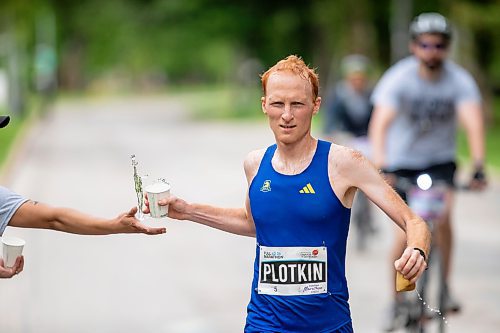 BROOK JONES / FREE PRESS
David Plotkin (right) grabs a cup of water from Manitoba Marathon volunteer Vern Dalusong as he runs down Wellington Crescent while competing in the men's full marathon, which was the 46th running of the Manitoba Marathon in Winnipeg, Man., Sunday, June 16, 2024.