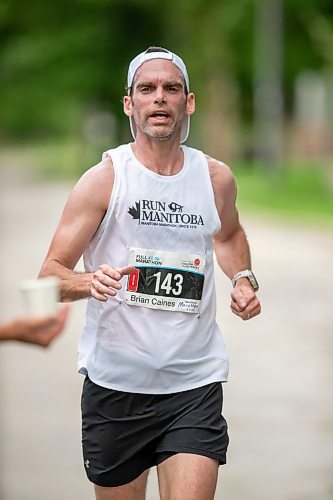 BROOK JONES / FREE PRESS
Brian Caines is focused on grabbing a cup of water at a hydration station as he runs down Wellington Crescent while competing in the men's full marathon, which was the 46th running of the Manitoba Marathon in Winnipeg, Man., Sunday, June 16, 2024.