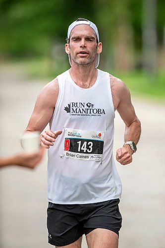 BROOK JONES / FREE PRESS
Brian Caines is focused on grabbing a cup of water at a hydration station as he runs down Wellington Crescent while competing in the men's full marathon, which was the 46th running of the Manitoba Marathon in Winnipeg, Man., Sunday, June 16, 2024.