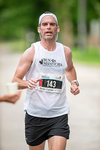 BROOK JONES / FREE PRESS
Brian Caines is focused on grabbing a cup of water at a hydration station as he runs down Wellington Crescent while competing in the men's full marathon, which was the 46th running of the Manitoba Marathon in Winnipeg, Man., Sunday, June 16, 2024.