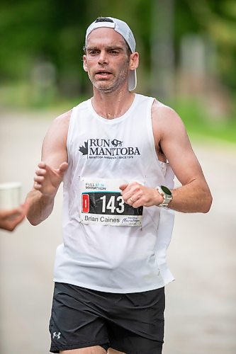 BROOK JONES / FREE PRESS
Brian Caines is focused on grabbing a cup of water at a hydration station as he runs down Wellington Crescent while competing in the men's full marathon, which was the 46th running of the Manitoba Marathon in Winnipeg, Man., Sunday, June 16, 2024.