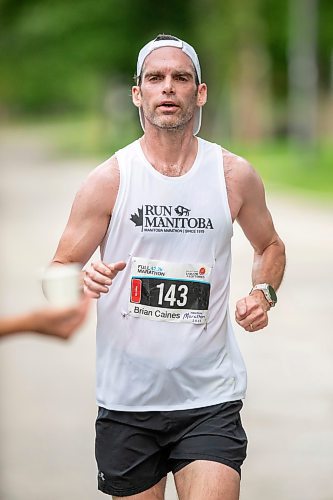 BROOK JONES / FREE PRESS
Brian Caines is focused on grabbing a cup of water at a hydration station as he runs down Wellington Crescent while competing in the men's full marathon, which was the 46th running of the Manitoba Marathon in Winnipeg, Man., Sunday, June 16, 2024.