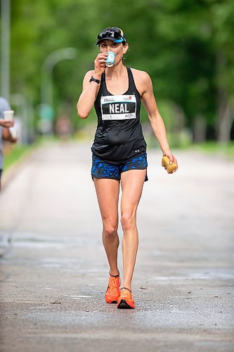 BROOK JONES / FREE PRESS
Winnipegger Dawn Neil takes a sip of Nuun Endurance sport drink while cooling off with a water-soaked sponge at a fluids station as she runs down Wellington Crescent on her way to winning the women's full marathon, which was the 46th running of the Manitoba Marathon in Winnipeg, Man., Sunday, June 16, 2024.