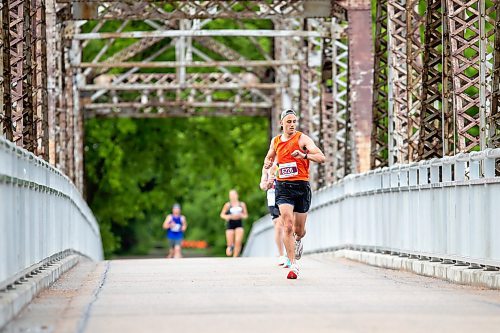 BROOK JONES / FREE PRESS
A runner checks his watch while he crosses the BDI bridge as compete in half marathon at the 46th Manitoba Marathon in Winnipeg, Man., Sunday, June 16, 2024.