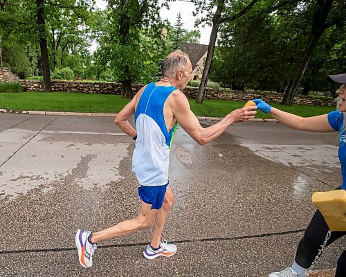 BROOK JONES / FREE PRESS
Full marathon participant Karl Sproll Sr. reached out for a water-soaked sponge from Manitoba Marathon volunteer Kristen Friess at a fluids station along Wellington Crescent during the 46th running of the Manitoba Marathon in Winnipeg, Man., Sunday, June 16, 2024.