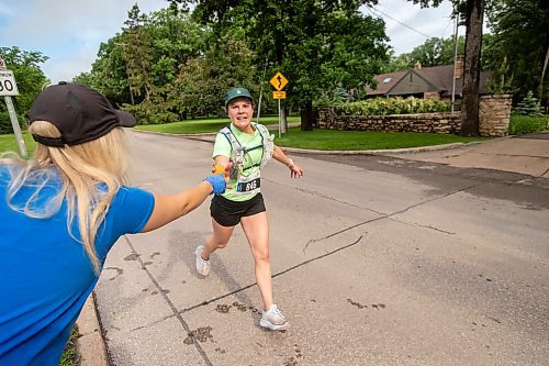 BROOK JONES / FREE PRESS
Full marathon participant Justina Tychanski (right) reached out for a water-soaked sponge from Kristen Friess at a fluids station along Wellington Crescent during the 46th running of the Manitoba Marathon in Winnipeg, Man., Sunday, June 16, 2024.