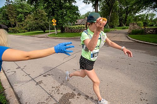 BROOK JONES / FREE PRESS
Full marathon participant Justina Tychanski cools off with a water-soaked sponge at a fluids station as she runs down Wellington Crescent during the 46th running of the Manitoba Marathon in Winnipeg, Man., Sunday, June 16, 2024.