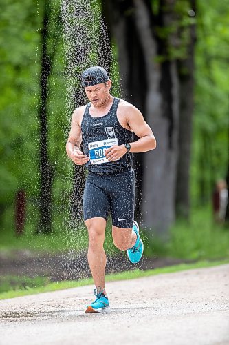 BROOK JONES./ FREE PRESS
A member of Team Pace Makers runs under a makeshift shower at a fluids station volunteer run by Eastman Flames U14 and U16 ringette teams near Crescent Drive Park during the marathon relay at the 46th Manitoba Marathon in Winnipeg, Man., Sunday, June 16, 2024.