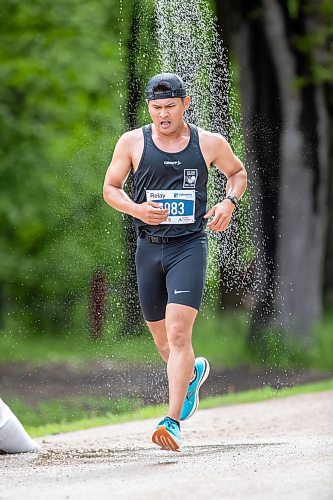 BROOK JONES./ FREE PRESS
A member of Team Pace Makers runs under a makeshift shower at a fluids station volunteer run by Eastman Flames U14 and U16 ringette teams near Crescent Drive Park during the marathon relay at the 46th Manitoba Marathon in Winnipeg, Man., Sunday, June 16, 2024.