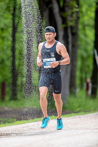 BROOK JONES./ FREE PRESS
A member of Team Pace Makers runs under a makeshift shower at a fluids station volunteer run by Eastman Flames U14 and U16 ringette teams near Crescent Drive Park during the marathon relay at the 46th Manitoba Marathon in Winnipeg, Man., Sunday, June 16, 2024.