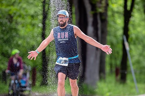 BROOK JONES./ FREE PRESS
Full marathon participant Tim Coombs runs under a makeshift shower at a fluids station volunteer run by Eastman Flames U14 and U16 ringette teams near Crescent Drive Park during the marathon relay at the 46th Manitoba Marathon in Winnipeg, Man., Sunday, June 16, 2024.