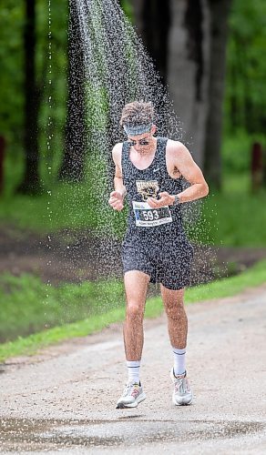 BROOK JONES./ FREE PRESS
Full marathon participant Adam Naylor runs under a makeshift shower at a fluids station volunteer run by Eastman Flames U14 and U16 ringette teams near Crescent Drive Park during the marathon relay at the 46th Manitoba Marathon in Winnipeg, Man., Sunday, June 16, 2024.