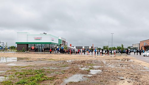 MIKE DEAL / FREE PRESS
Lovers of fried pastries endured long lines and rainy conditions to be some of the first to purchase Krispy Kreme donuts during it&#x2019;s grand opening early Tuesday.
240618 - Tuesday, June 18, 2024.