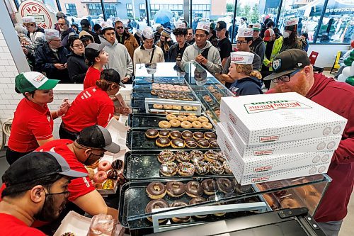 MIKE DEAL / FREE PRESS
Lovers of fried pastries endured long lines and rainy conditions to be some of the first to purchase Krispy Kreme donuts during it&#x2019;s grand opening early Tuesday.
240618 - Tuesday, June 18, 2024.