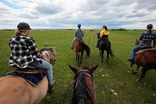 Kim Richardson (second from right in yellow) of Lucky Break Ranch leads a trail ride through the prairie near the riding stable and ranch southwest of Rivers on Wednesday afternoon. The ranch holds weekly barrel-racing jackpots on Thursday evenings. Pick up the June 27 edition of Westman This Week for a story and more photos from Lucky Break Ranch. (Tim Smith/The Brandon Sun)