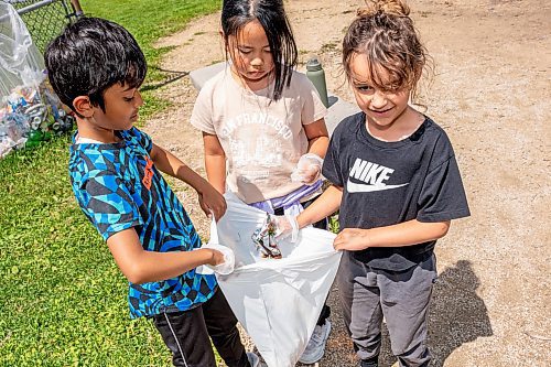 NIC ADAM / FREE PRESS
Students from Lynne MacDuff’s grade 1 & 2 class, at Kent Road School, clean up garbage around the schools playground Wednesday afternoon.
240619 - Wednesday, June 19, 2024.

Reporter: Matt Frank