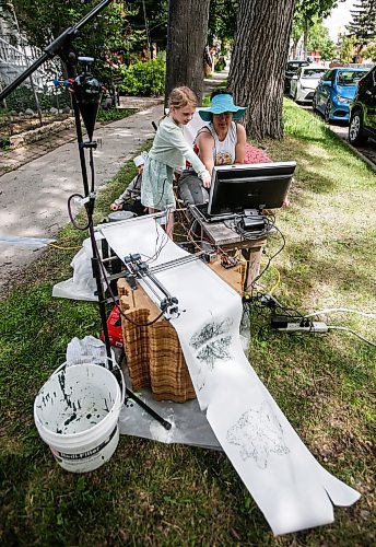 JOHN WOODS / FREE PRESS
Ellianna, Theo and their father Dave stopped by to visit media artist Erika Jean Lincoln as she works on her Winnipeg project Arboreal Intuitions - an urban tree memorial on Clifton Street in Winnipeg Sunday, June 23, 2024. Lincoln&#x2019;s project uses a computer drawing plotter with gravity fed ink to draw digital images of the ring patterns from the stumps of Winnipeg&#x2019;s harvested trees.

Reporter: ?