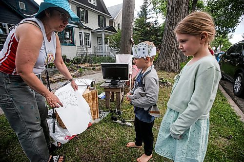 JOHN WOODS / FREE PRESS
Ellianna, Theo and their father Dave stopped by to visit media artist Erika Jean Lincoln as she works on her Winnipeg project Arboreal Intuitions - an urban tree memorial on Clifton Street in Winnipeg Sunday, June 23, 2024. Lincoln&#x2019;s project uses a computer drawing plotter with gravity fed ink to draw digital images of the ring patterns from the stumps of Winnipeg&#x2019;s harvested trees.

Reporter: ?