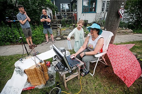 JOHN WOODS / FREE PRESS
Ellianna, Theo and their father Dave stopped by to visit media artist Erika Jean Lincoln as she works on her Winnipeg project Arboreal Intuitions - an urban tree memorial on Clifton Street in Winnipeg Sunday, June 23, 2024. Lincoln&#x2019;s project uses a computer drawing plotter with gravity fed ink to draw digital images of the ring patterns from the stumps of Winnipeg&#x2019;s harvested trees.

Reporter: ?