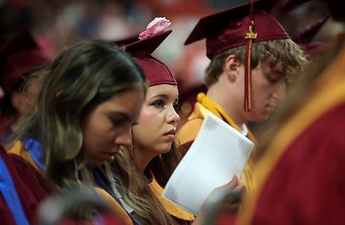 A graduate fans herself while watching fellow grads receive their diplomas. (Tim Smith/The Brandon Sun)