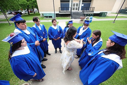 Prairie Hope High School student Tearan Delowsky washes herself in smoke during an Indigenous smudging ceremony conducted by Indigenous academic support Cheyanne Seaton (centre) outside the Western Manitoba Centennial Auditorium on Thursday afternoon prior to the school graduation. See story on Page A2. (Matt Goerzen/The Brandon Sun) 