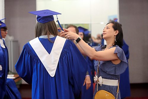 Educational assistant Jovan Lin helps a student adjust their graduation cap and tassle before the graduation ceremony for Prairie Hope High School at the Western Manitoba Centennial Auditorium on Thursday afternoon. (Matt Goerzen/The Brandon Sun)