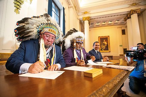 MIKAELA MACKENZIE / FREE PRESS

Minegoziibe Anishinaabe chief Derek Nepinak (left), Wuskwi Sipihk First Nation chief Elwood Zastre, and premier Wab Kinew sign an agreement between three First Nations and the province of Manitoba at the Manitoba Legislative Building on Friday, June 28, 2024.

For Martin Cash story.

