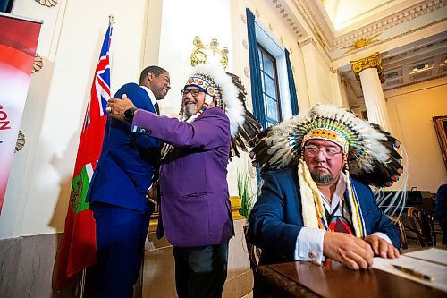 MIKAELA MACKENZIE / FREE PRESS

Economic development, investment, trade and natural resources minister Jamie Moses (left) embraces Wuskwi Sipihk First Nation chief Elwood Zastre as Minegoziibe Anishinaabe chief Derek Nepinak signs an agreement between three First Nations and the province of Manitoba at the Manitoba Legislative Building on Friday, June 28, 2024.

For Martin Cash story.

