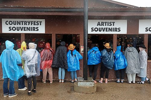 28062024
Festival-goers wear rain ponchos during pouring rain at Dauphin&#x2019;s Countryfest on Friday afternoon. (Tim Smith/The Brandon Sun)