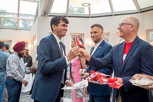 BROOK JONES / FREE PRESS
A CanadIan citizenship ceremony was hosted on Canada Day at the Pavilion at Assiniboine Park in Winnipeg, Man., Monday, July 1, 2024. Pictured: Amin Khoja (left) smiles as he receives a Canadian flag from Winnipeg Mayor Scott Gillingham after he took the oath of citizenship.