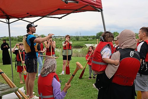 Families gather around a Voyageur canoe instructor at the Riverbank Discovery Centre on Canada Day. The Riverbank partially subsidized the cost of the canoe rides so more families could participate. (Charlotte McConkey/The Brandon Sun)