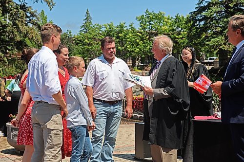 The Pretorius family from Namibia receive their citizenship documents from Dwight Macaulay after being sworn in as citizens. (Charlotte McConkey/The Brandon Sun)