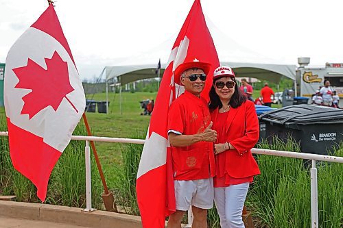 A couple pose in front of the Canadian flag adorned in Canada's national colours at the Riverbank Discovery Centre. (Charlotte McConkey/The Brandon Sun)