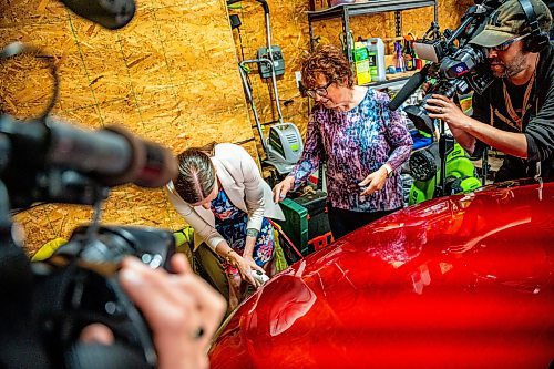 NIC ADAM / FREE PRESS
Electric vehicle owner Shelley Kowalchuck (centre right) shows Environment and Climate Change Minister Tracy Schmidt (centre left) and press how to pulg in her car in her home on Tuesday.
240702 - Tuesday, July 02, 2024.

Reporter: Martin Cash