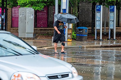 NIC ADAM / FREE PRESS
A man crosses at the corner of Smith Street and Graham Avenue on a rainy Thursday afternoon.
240704 - Thursday, July 04, 2024.

Reporter: