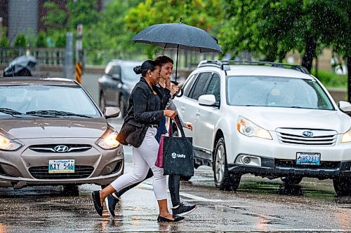 NIC ADAM / FREE PRESS
Two women cross at the corner of Smith Street and Graham Avenue on a rainy Thursday afternoon.
240704 - Thursday, July 04, 2024.

Reporter: