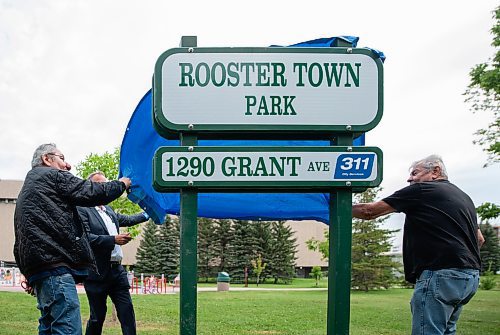 ETHAN CAIRNS / WINNIPEG FREE PRESS
Philip and Frank Sais remove the cover from the new sign at the announcement and unveiling for the renaming of Rooster Town Park in Winnipeg Tuesday August 23, 2022